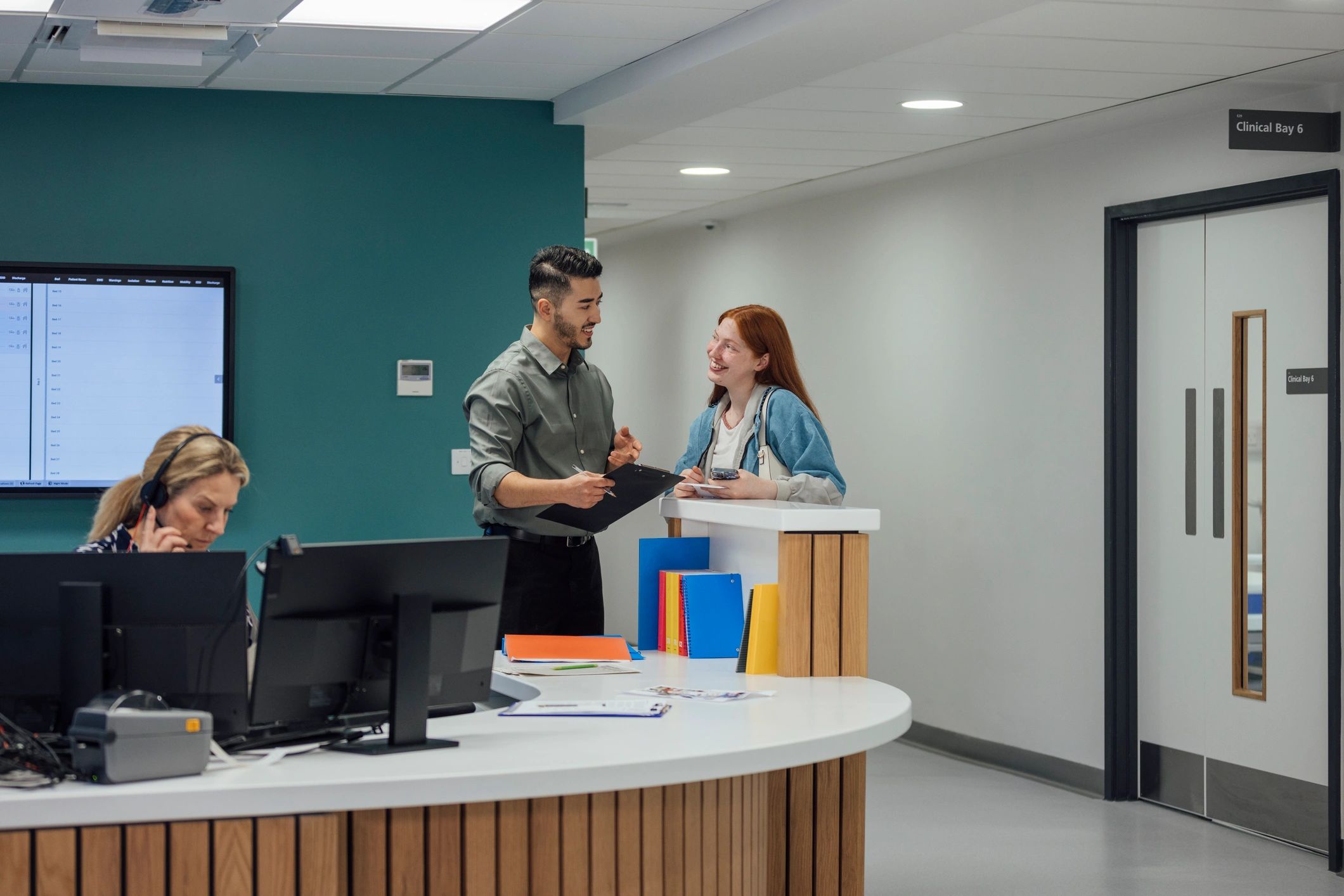 Healthcare professional assisting a patient at a medical reception desk