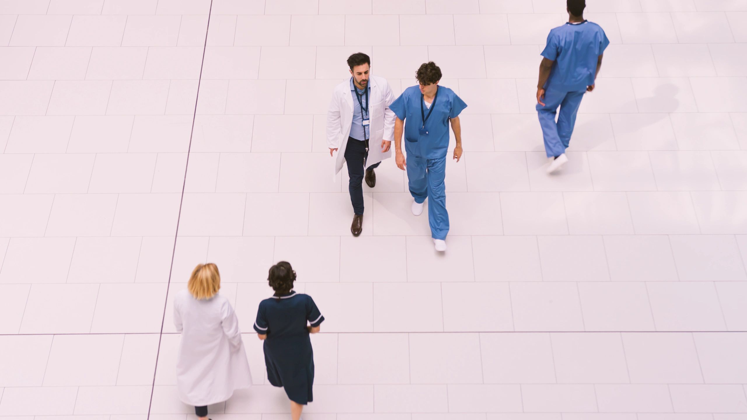 Medical staff walking through a modern hospital lobby